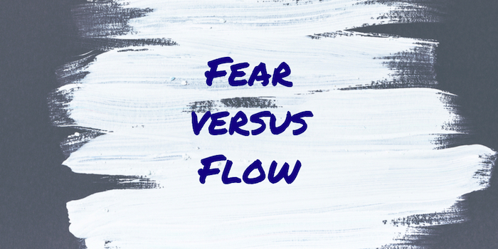 The words "Fear Versus Flow" on white paint