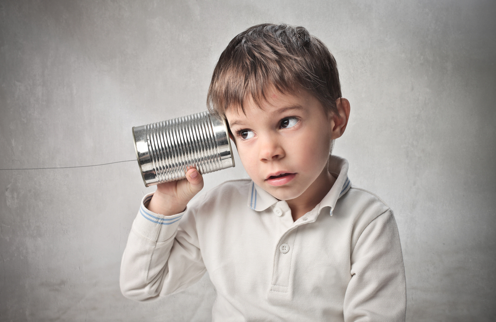 Boy listening to a tin can