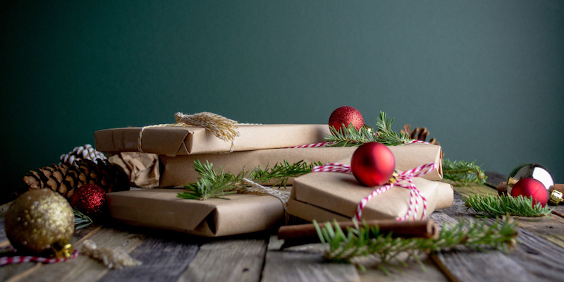 pile of books wrapped in brown paper with greenery