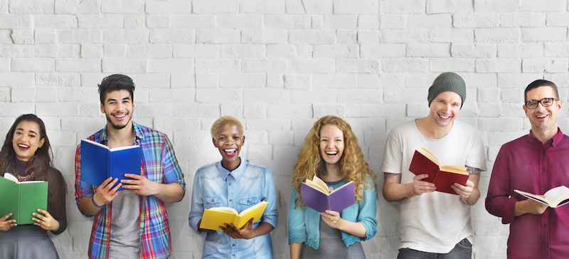 Diverse people holding books and smiling