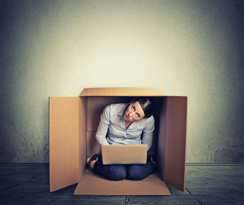 woman in box with a laptop, looking fearful