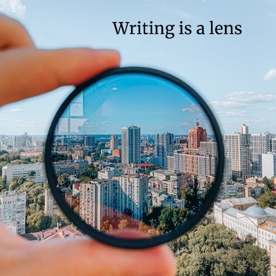 hand holding a lens filter up to a cityscape