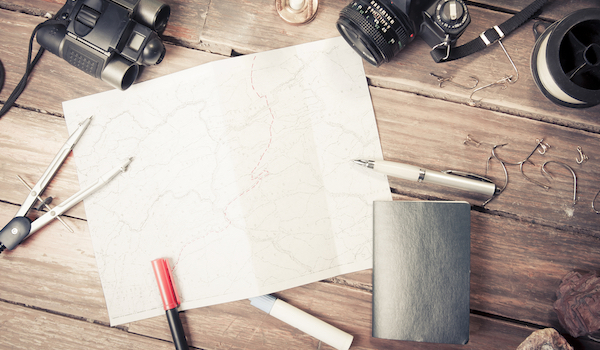 table with map, pens, journal, binoculars