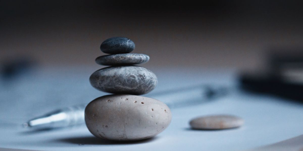 A pile of rocks balanced near pen and paper