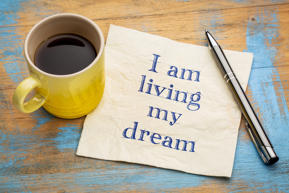 I am living my dream - positive affirmation words on a napkin with a cup of coffee