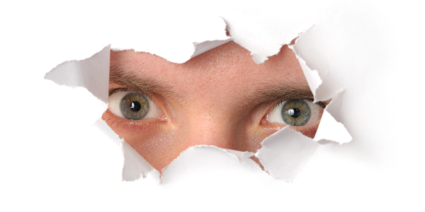 eyes looking through torn paper