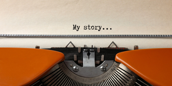 Orange typewriter, paper with words My story..."