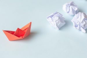 red paper boat with white crumpled papers